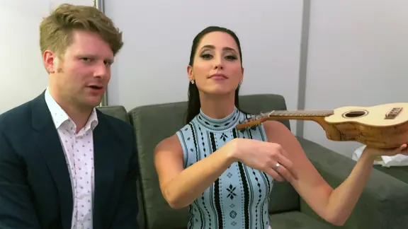 Stefan Spiegel mit der ESC-Kandidatin Elina Nechayeva, die eine Ukulele wie eine Geige hält.