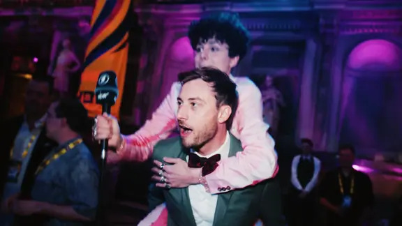 Consi trägt den dänischen ESC-Kandidaten Reiley auf seinen Schultern auf der Aftershowparty des türkisen Teppichs in Liverpool.