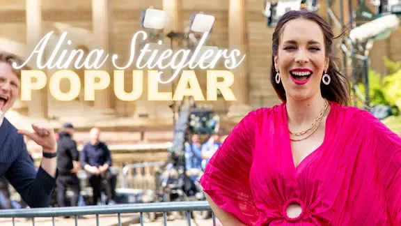 Alina Stiegler mit Stefan Spiegel am türkisfarbenen Teppich in Liverpool.