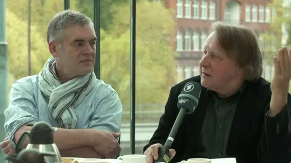 Jan Feddersen und Peter Urban sitzen an einem Tisch