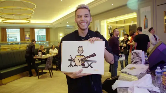 Malik Harris hält in London ein Piktogramm von sich hoch.