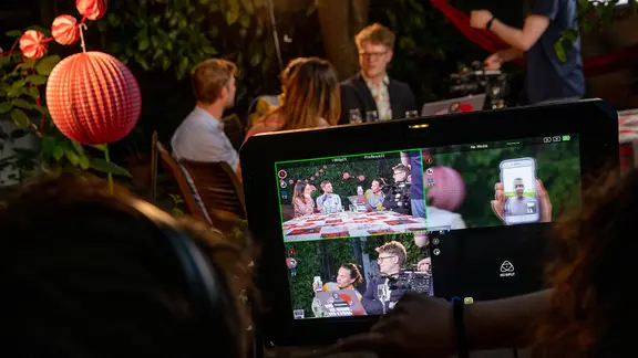 Blick auf einen Kameramonitor, dahinter sitzen Alina Stiegler, Constantin Zöller, Broder Breese und Stefan Spiegel an einem Tisch.