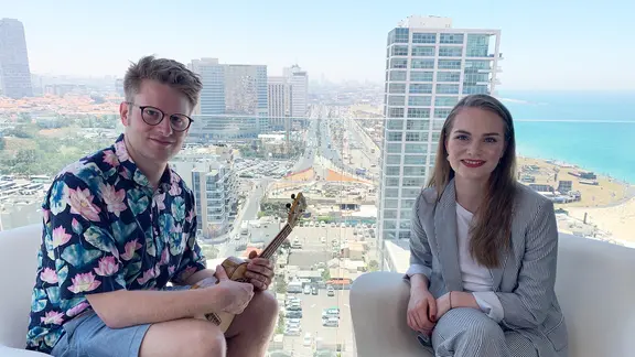 Stefan Spiegel sitzt mit Leonora auf einem Hotel-Balkon.