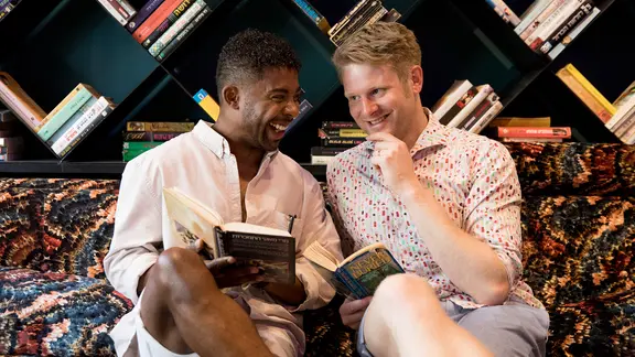Der schwedische ESC-Teilnehmer John Lundvik zusammen mit dem Modertor Stefan Spiegel vor einer Bücherwand.