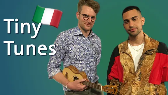 Stefan Spiegel steht mit Ukulele neben Mahmood aus Italien